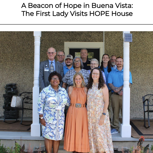 السيدة الأولى مع المجموعة التي تقف أمام دار الأمل (HOPE House)